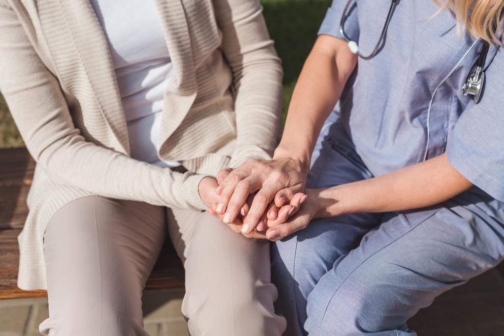 nurse and patient holding hands